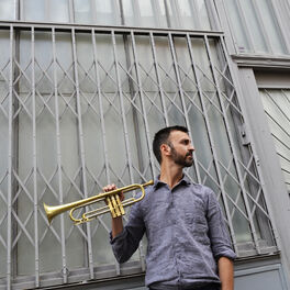 little girl playing trumpet on a gray background Stock Photo